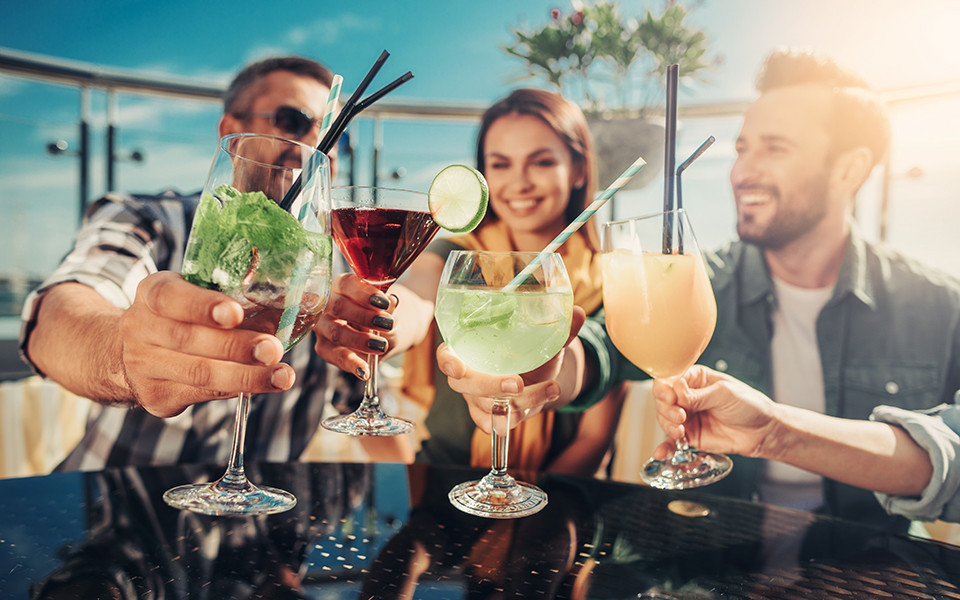 Freunde sto&szlig;en mit Cocktails an