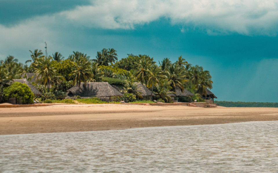 Idyllischer Strand mit Palmen und traditionellen H&uuml;tten auf Manda Toto Island.