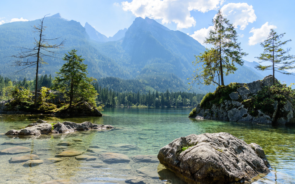Felsen und B&auml;ume im klaren Wasser des Hintersees vor dem Watzmann-Massiv im Berchtesgadener Land.